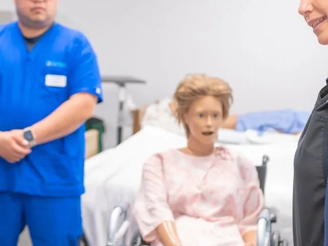 Egészségügyi gyakorlatvezető szimulációs bábun mutat be egy klinikai beavatkozást
